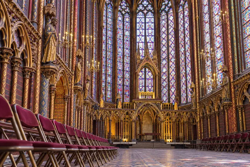 Burgunderrote Stühle vor der vergoldeten Altarschranke und den Buntglasfenstern der Sainte-Chapelle